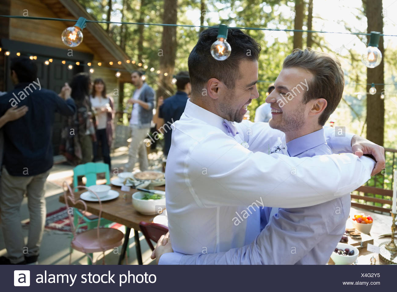 Affectionate Homosexual Couple Hugging On Balcony At Wedding