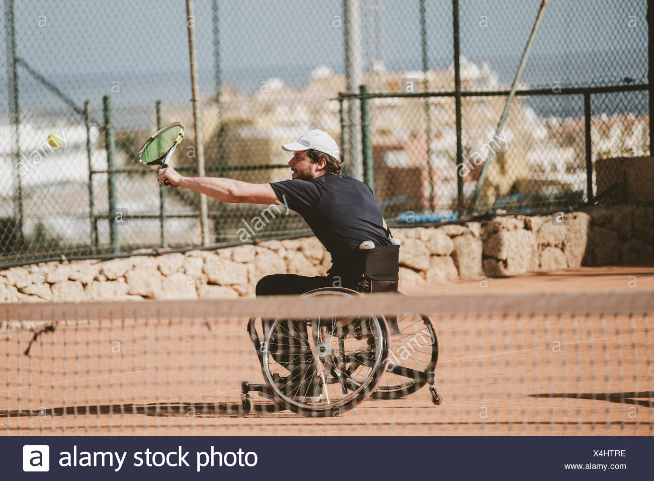 Mid adult Austrian paralympic tennis player playing on tennis court Stock Photo