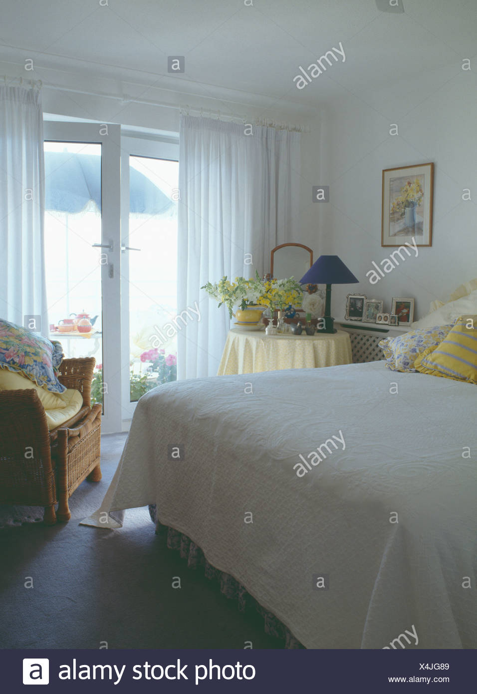 Seaside Bedroom With White Quilt On Bed And White Curtains