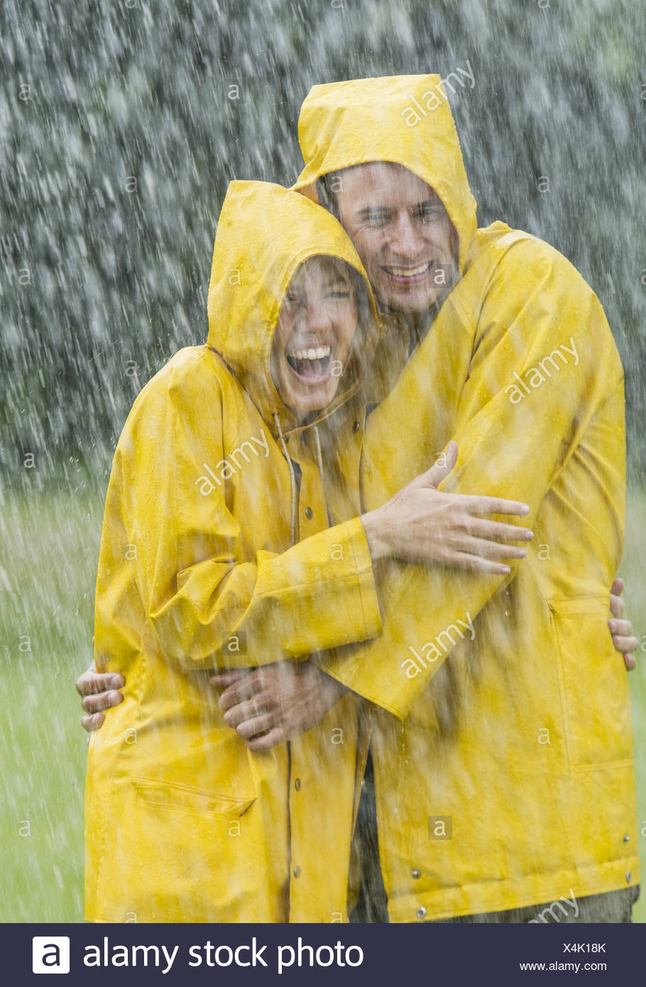 Paar Stehen In Gelben Regenjacken Im Regen Lachen Model Released Stock Photo Alamy