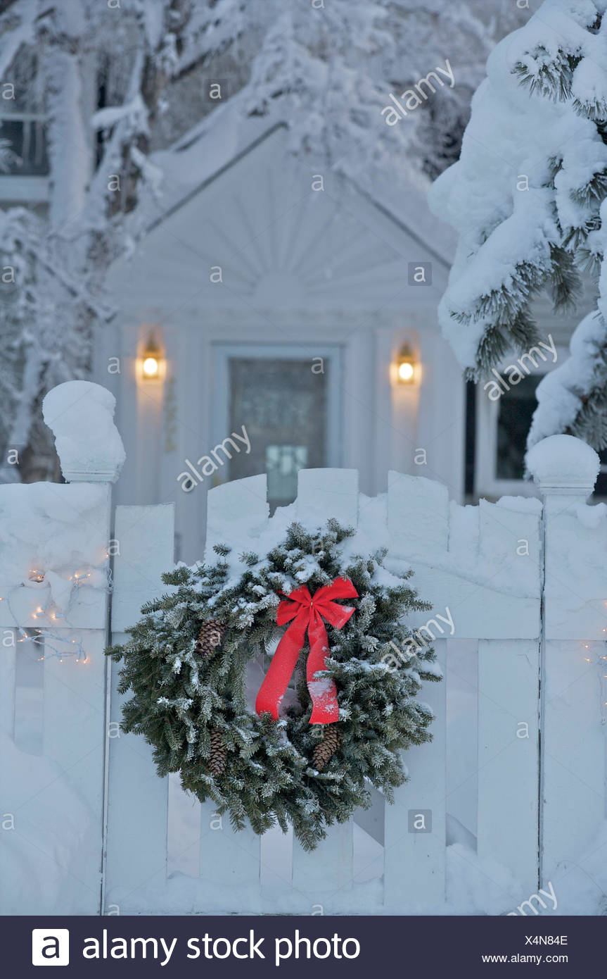 Holiday Wreath Hanging From The Front Gate Of A Home Surrounded By