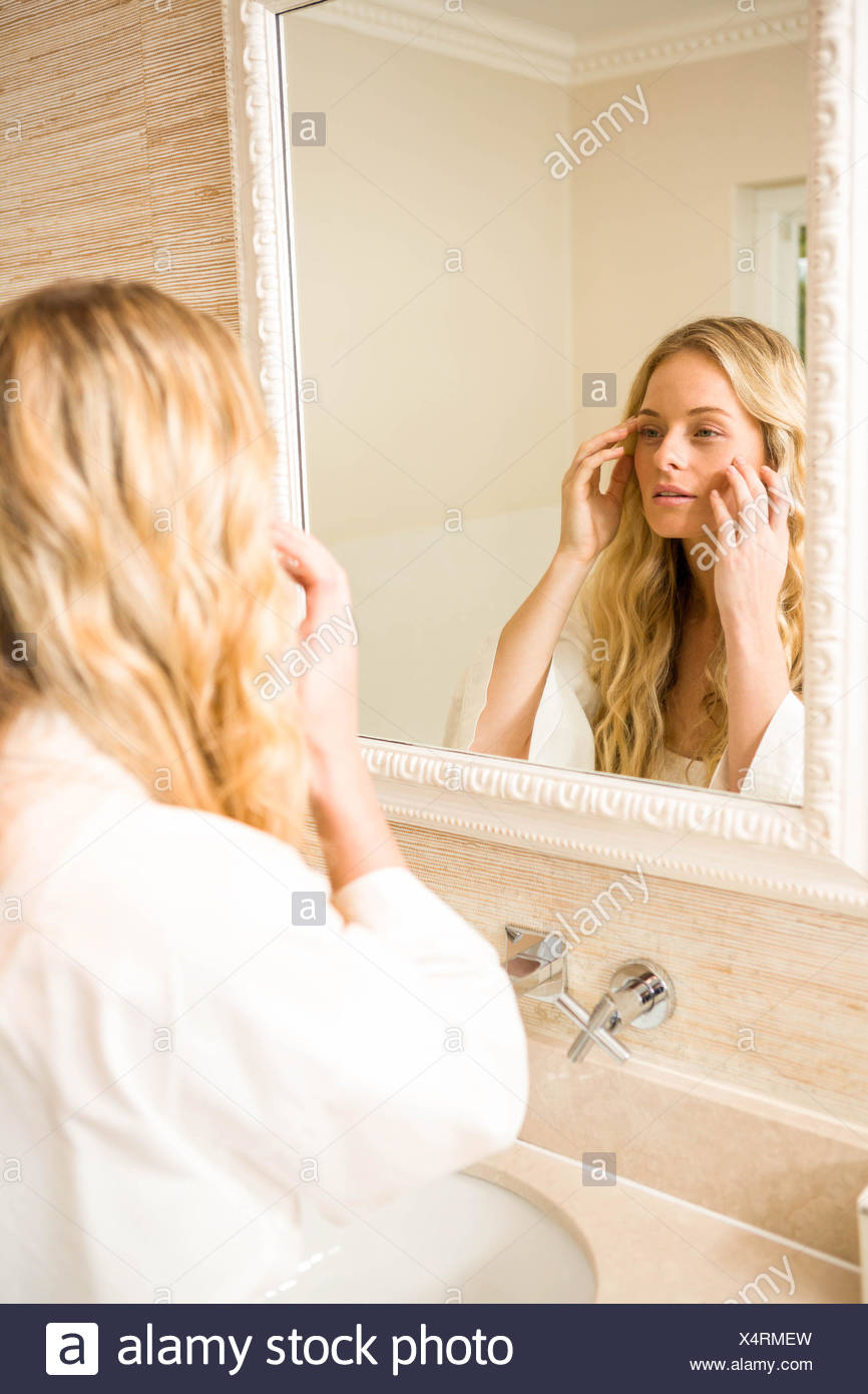 Pretty Woman Looking At Herself In The Mirror Stock Photo