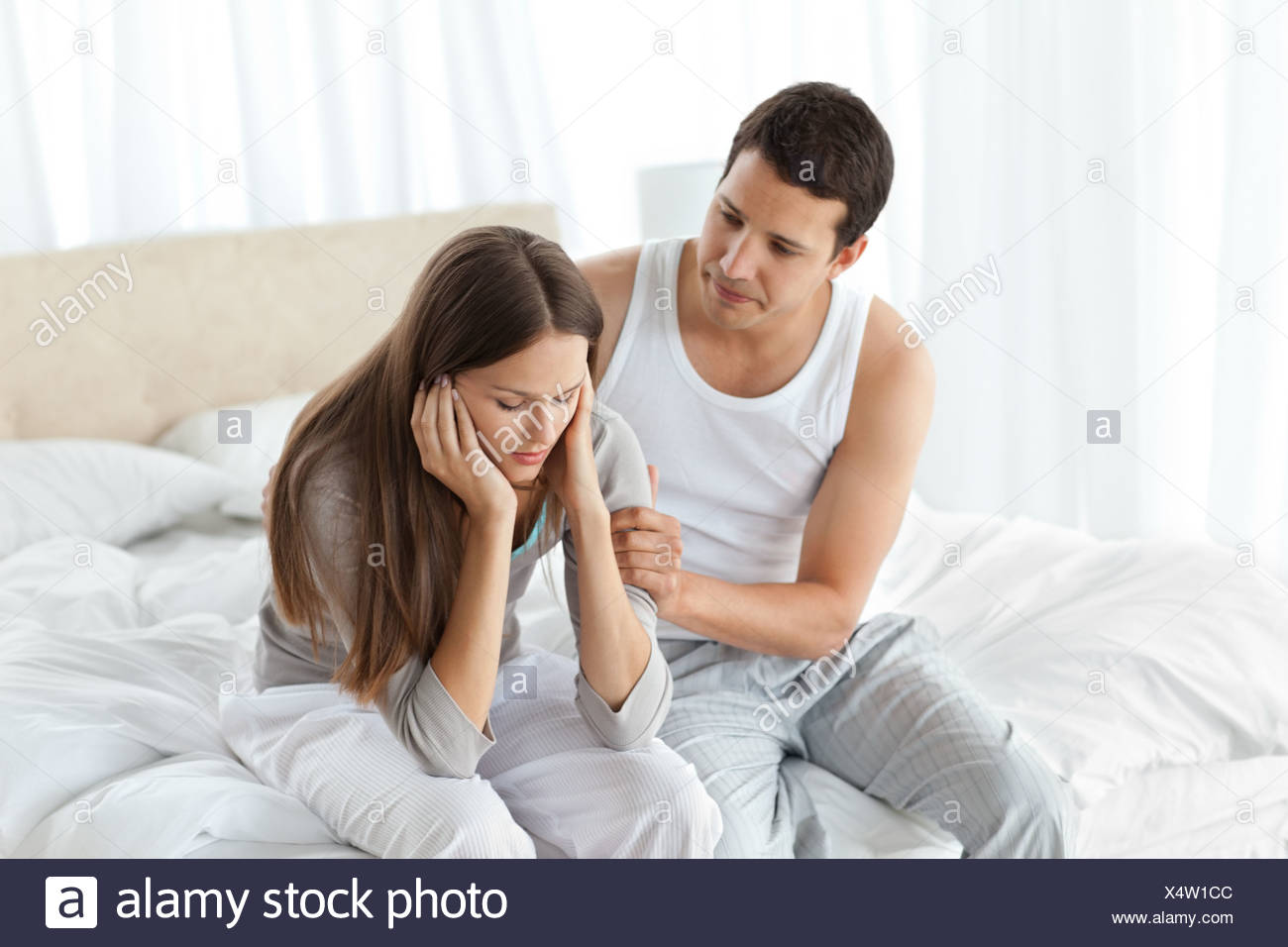 Handsome Man Comforting His Girlfriend Together On The Bed Stock