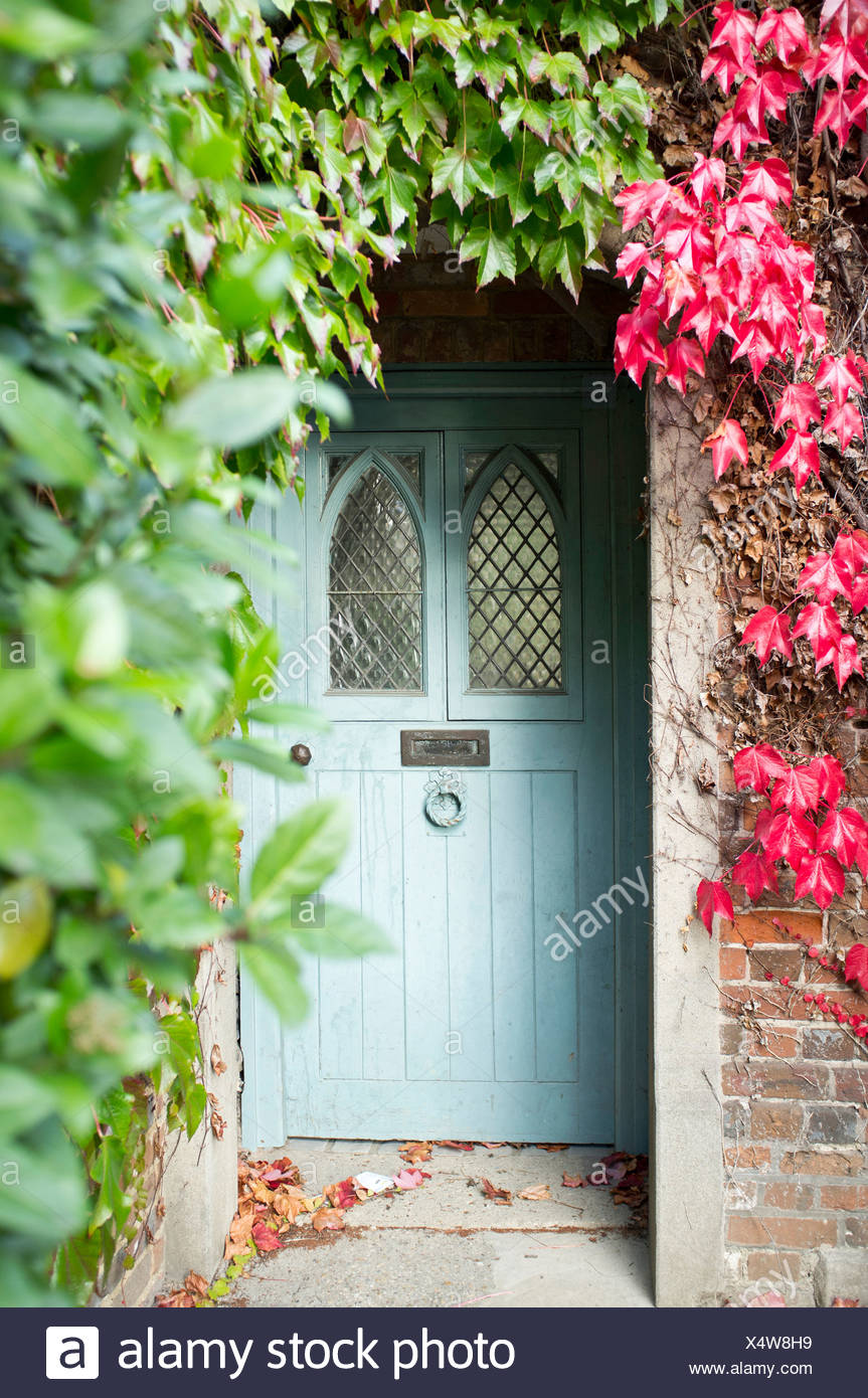 The Front Door Of A House Surrounded By Virginia Creeper