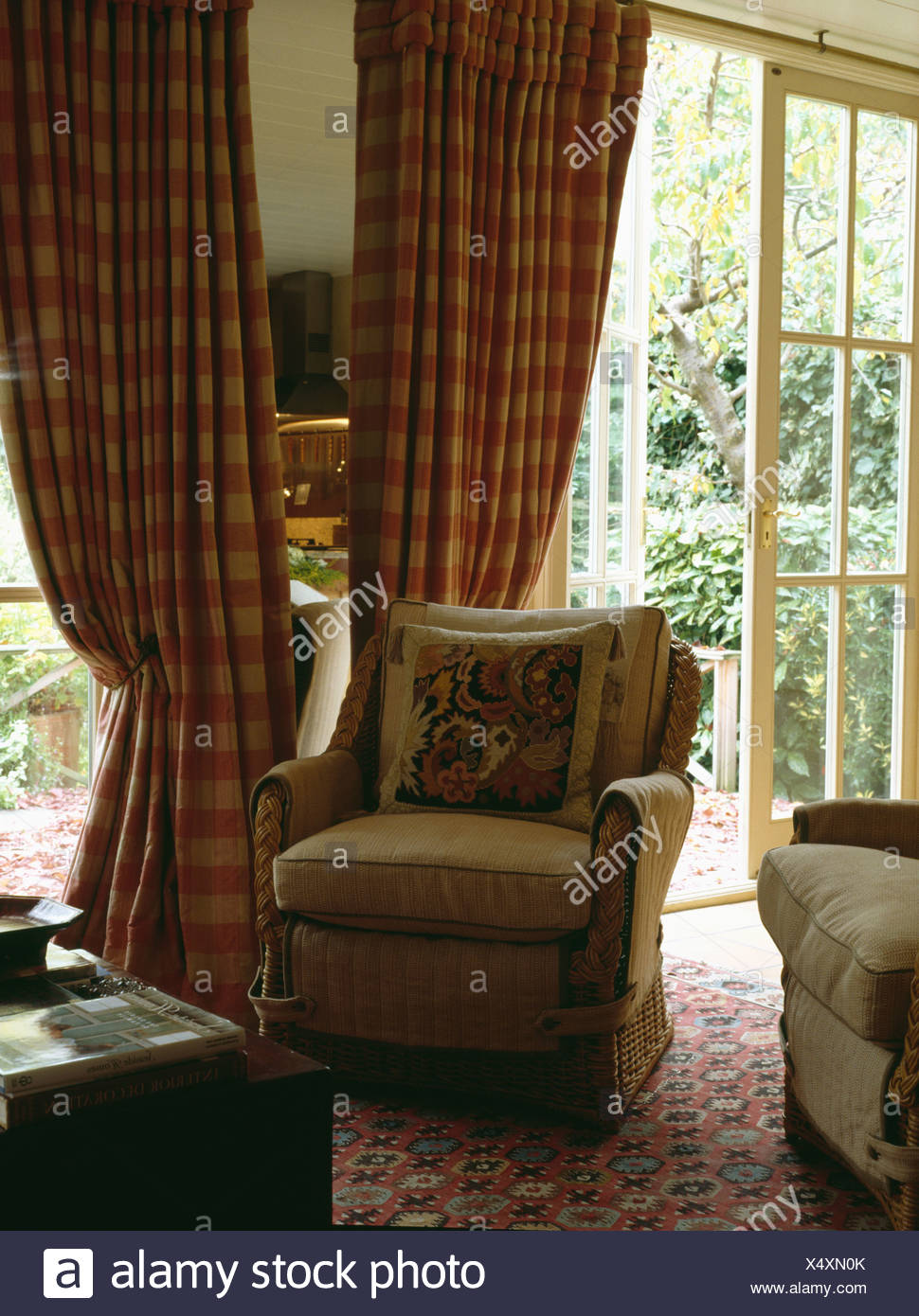 Beige Armchair In Front Of Red Checked Curtains At French Doors In