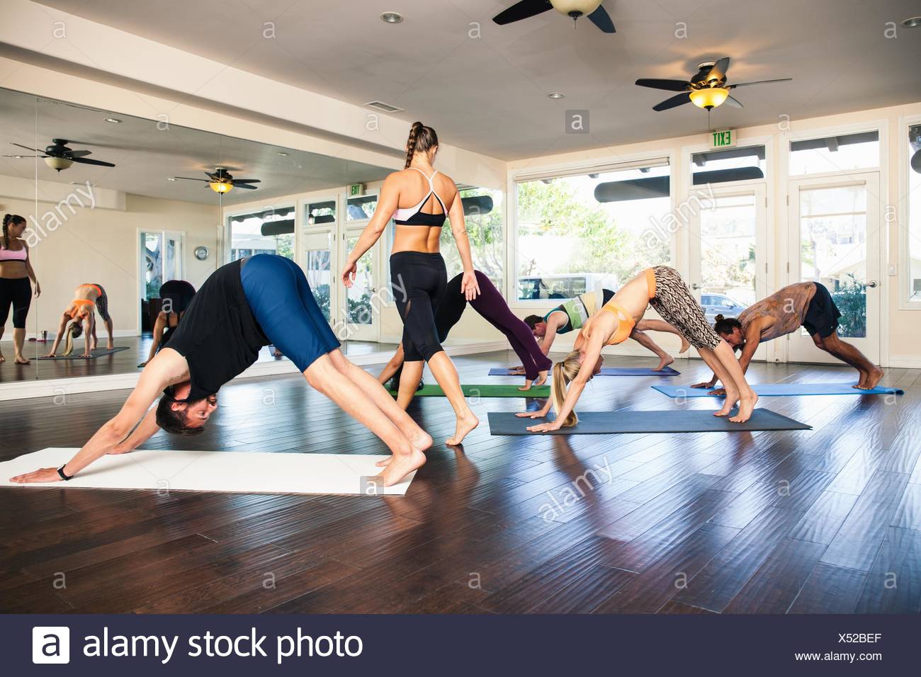 Yoga Instructor In Class With People In Downward Dog Position Stock Photo Alamy