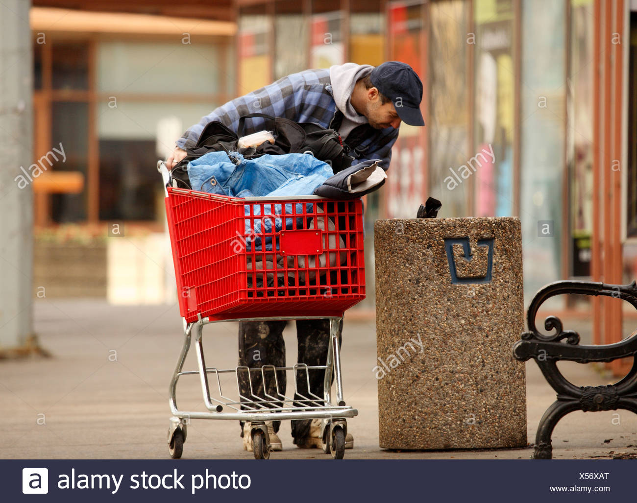 Homeless Man Checking The Garbage With Shopping Cart Stock Photo Alamy
