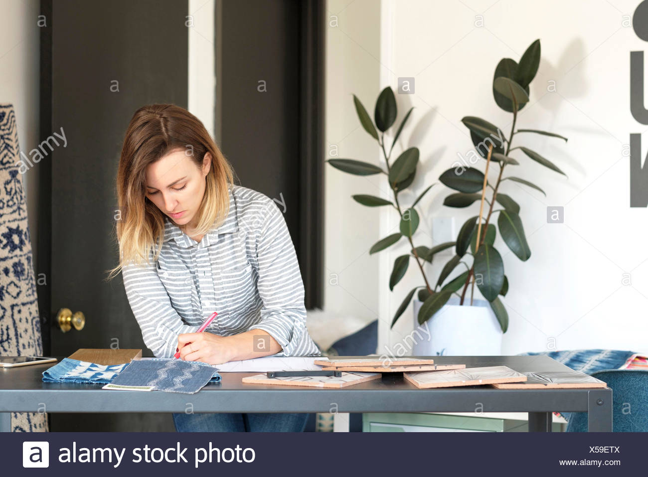 Female Interior Designer Drawing Designs At Desk In Retail