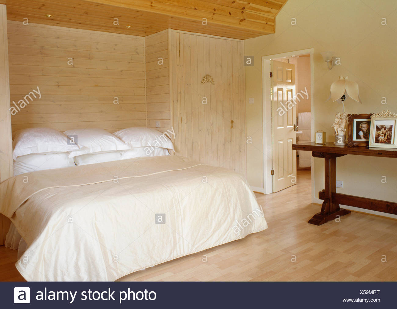 Pale Wood Paneled Wall Behind Bed With White Pillows And
