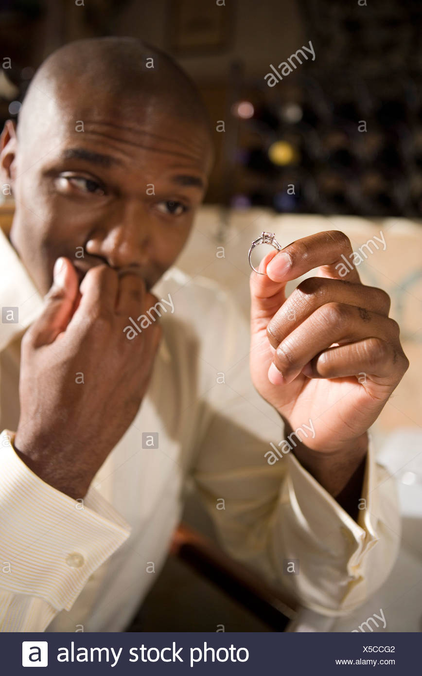 Young African American Man Nervously Holding And Looking At An