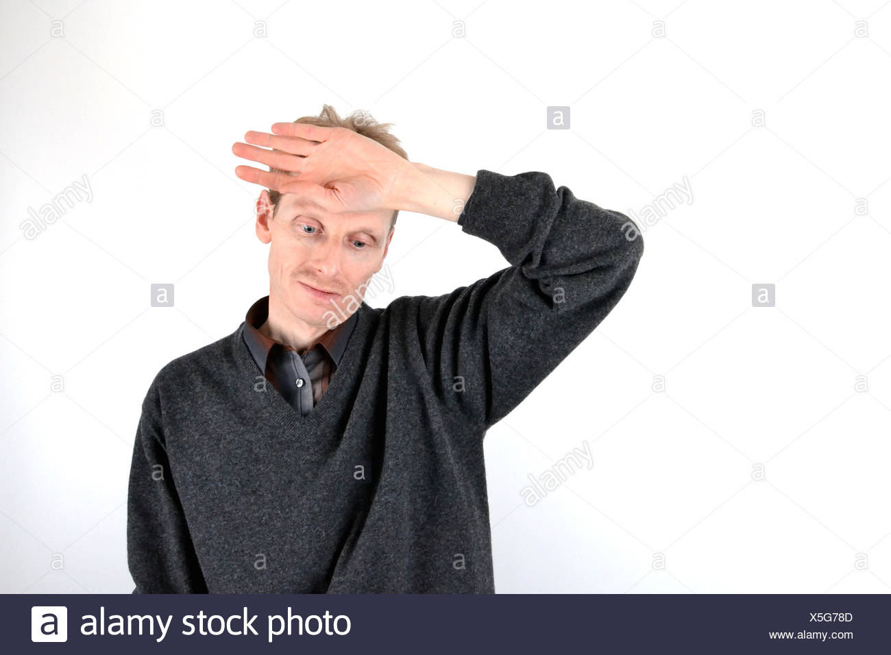 Blonde man who has his hand on his forehead Stock Photo