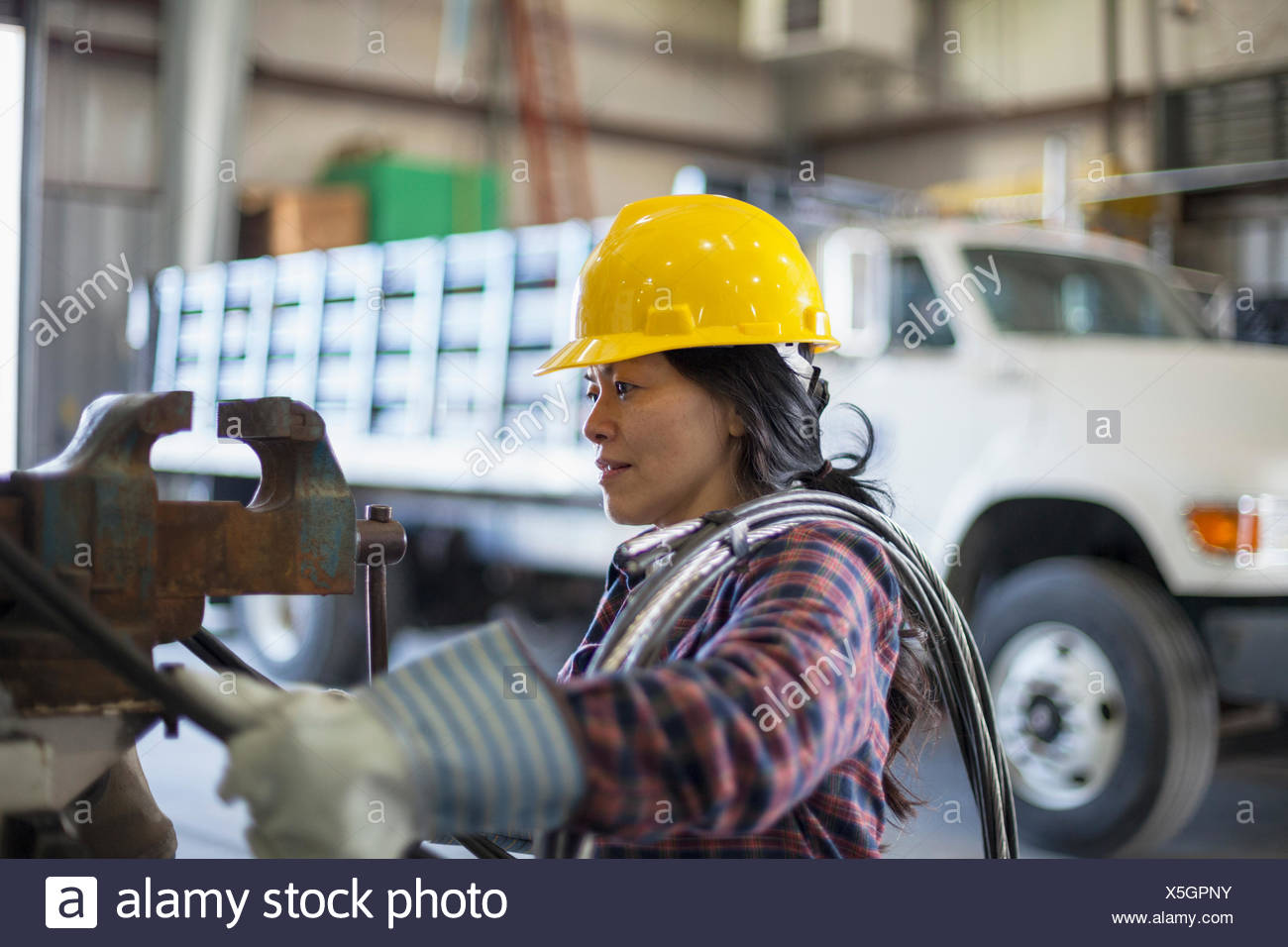 Female Power Engineer With Power Cable In Service Garage Stock