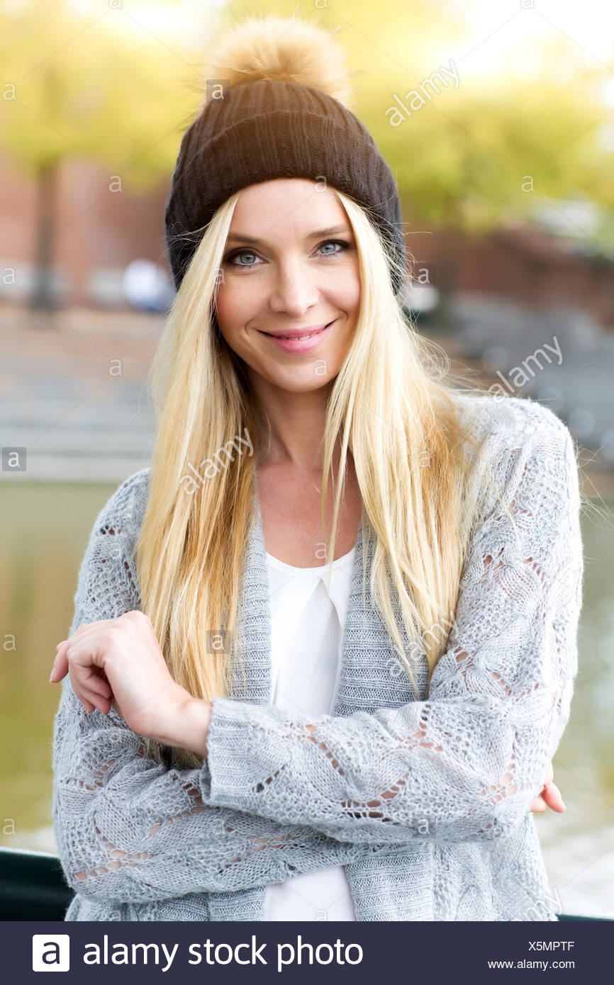 Portrait Of Smiling Young Woman Wearing Bobble Hat And Cardigan