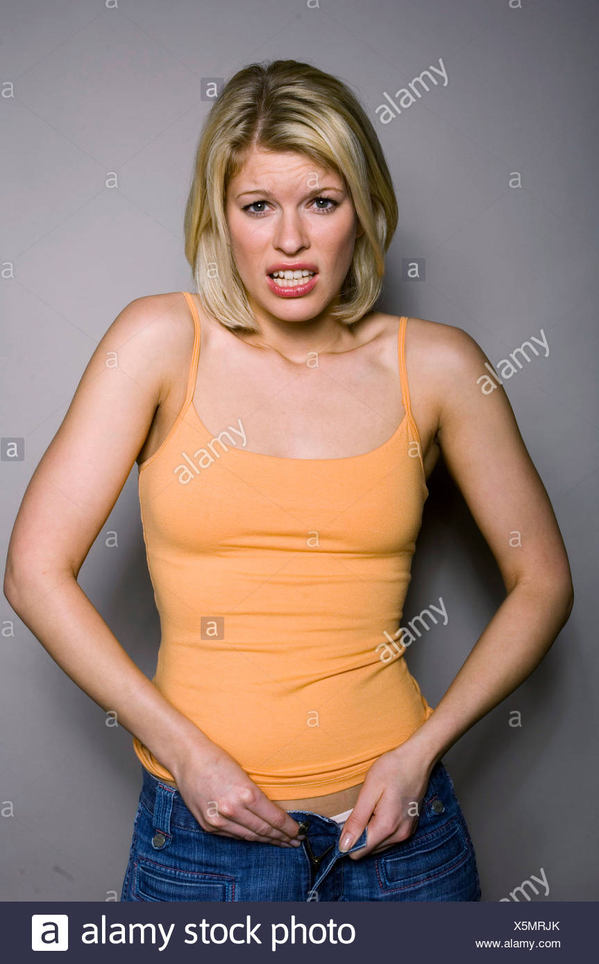 Female With Shoulder Length Blonde Hair Wearing Jeans And Pale