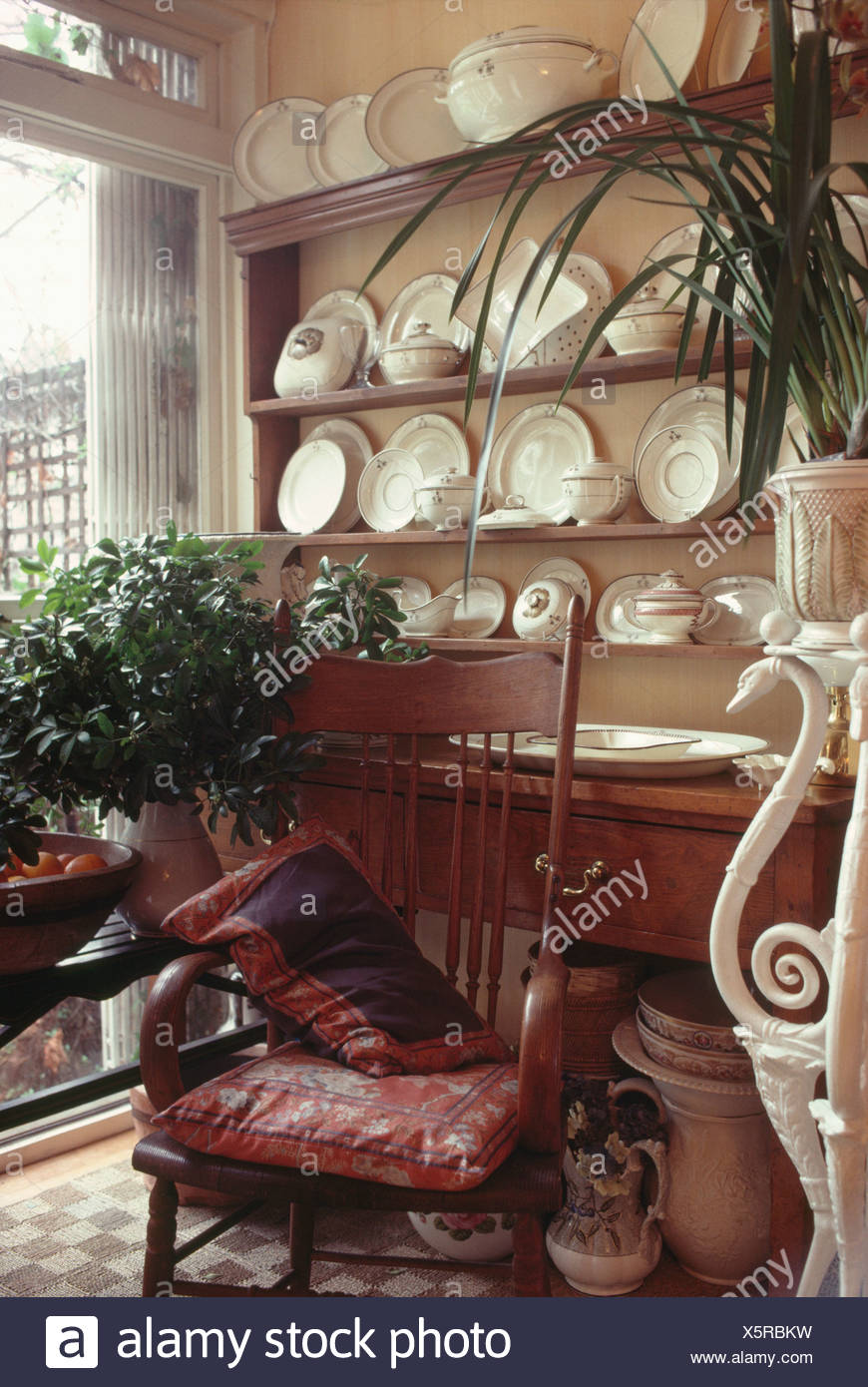 Antique Chair In Front Of Dresser With White Crockery In Corner Of