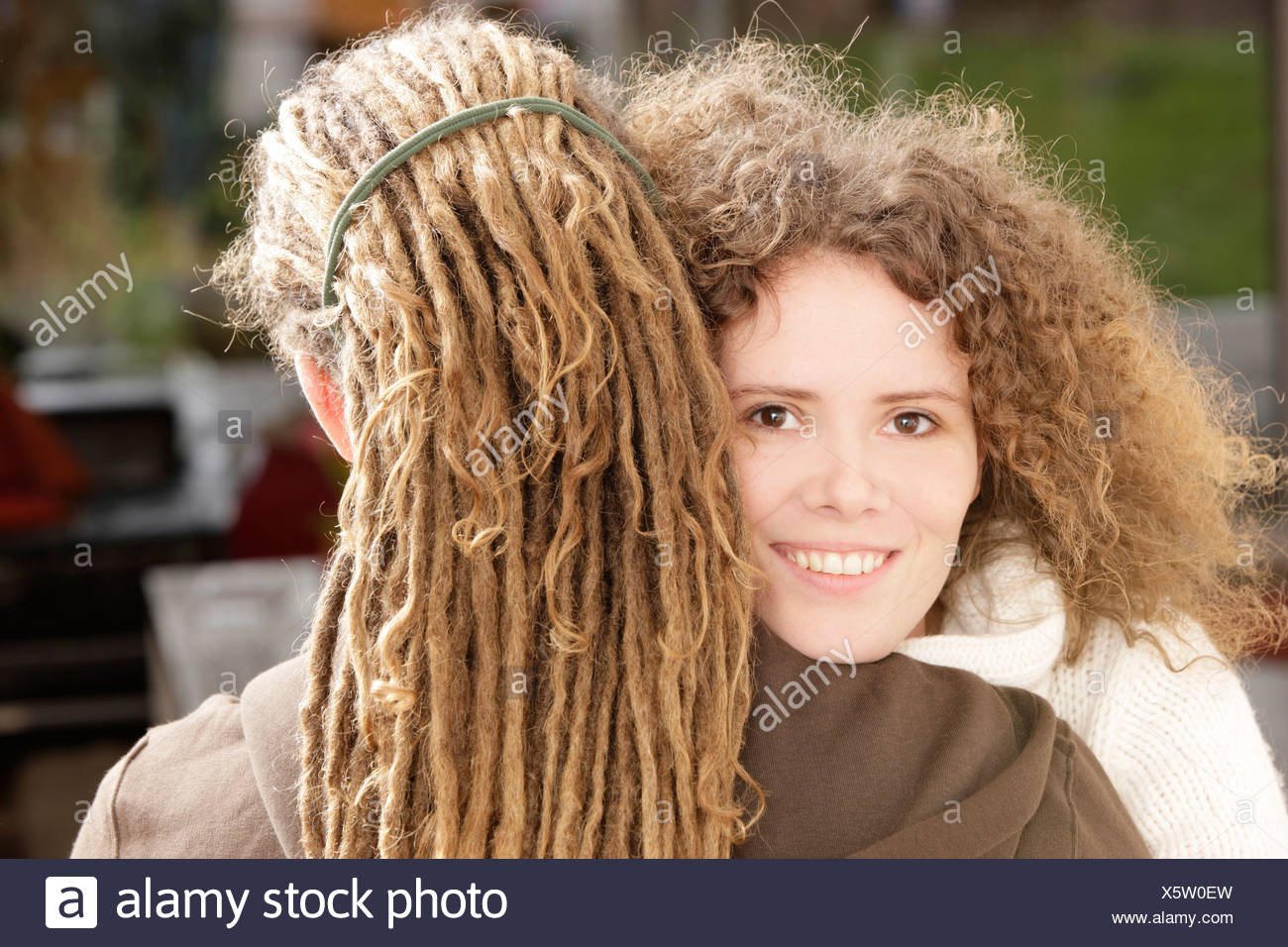 Woman With Curly Hair Smiling And A Man With Dreadlocks