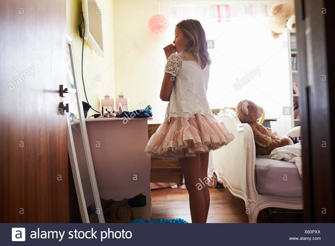 Young Girl Playing Dressing Up Game In Bedroom Stock Photo