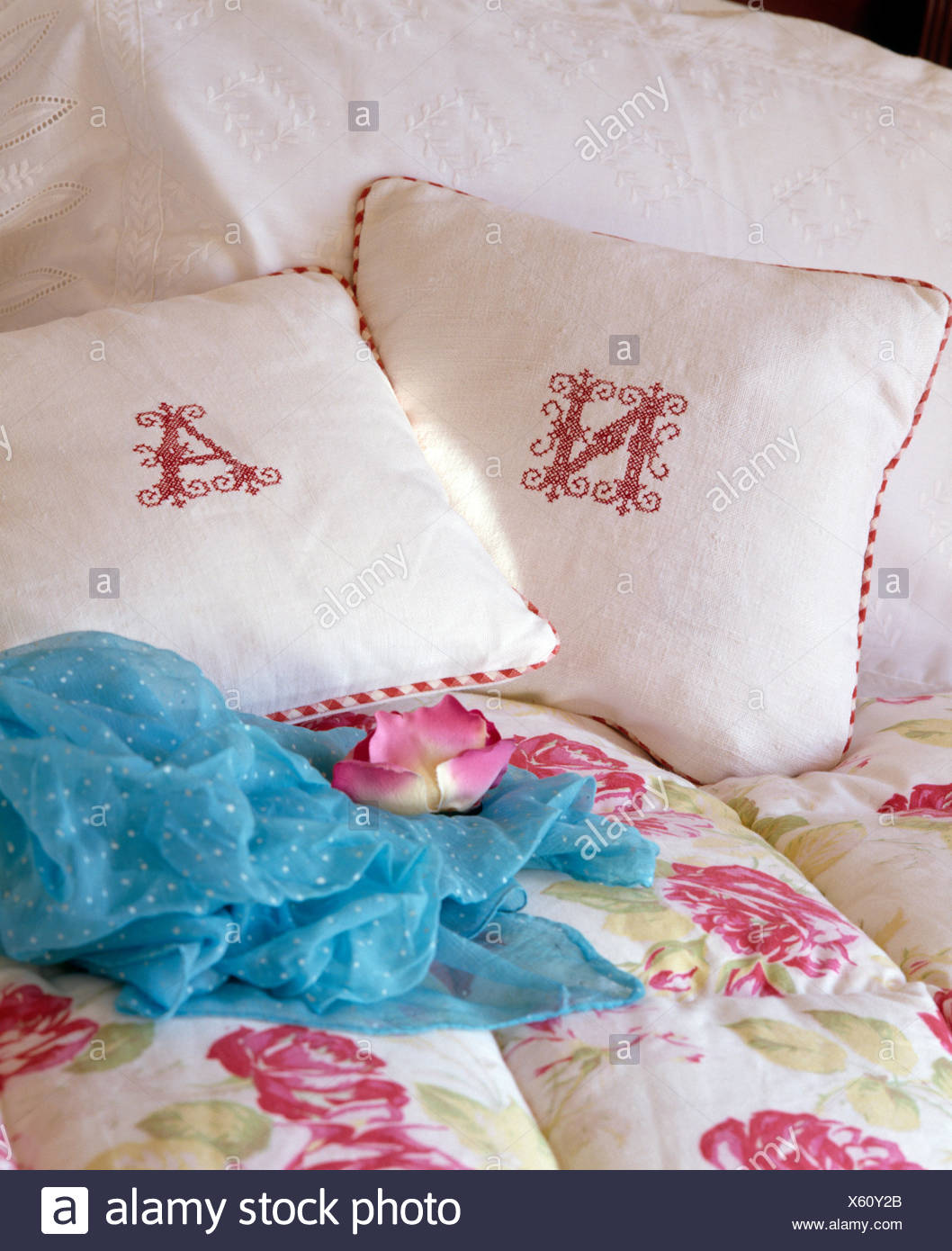 Monogrammed White Linen Cushions On Bed With Turquoise Scarf And
