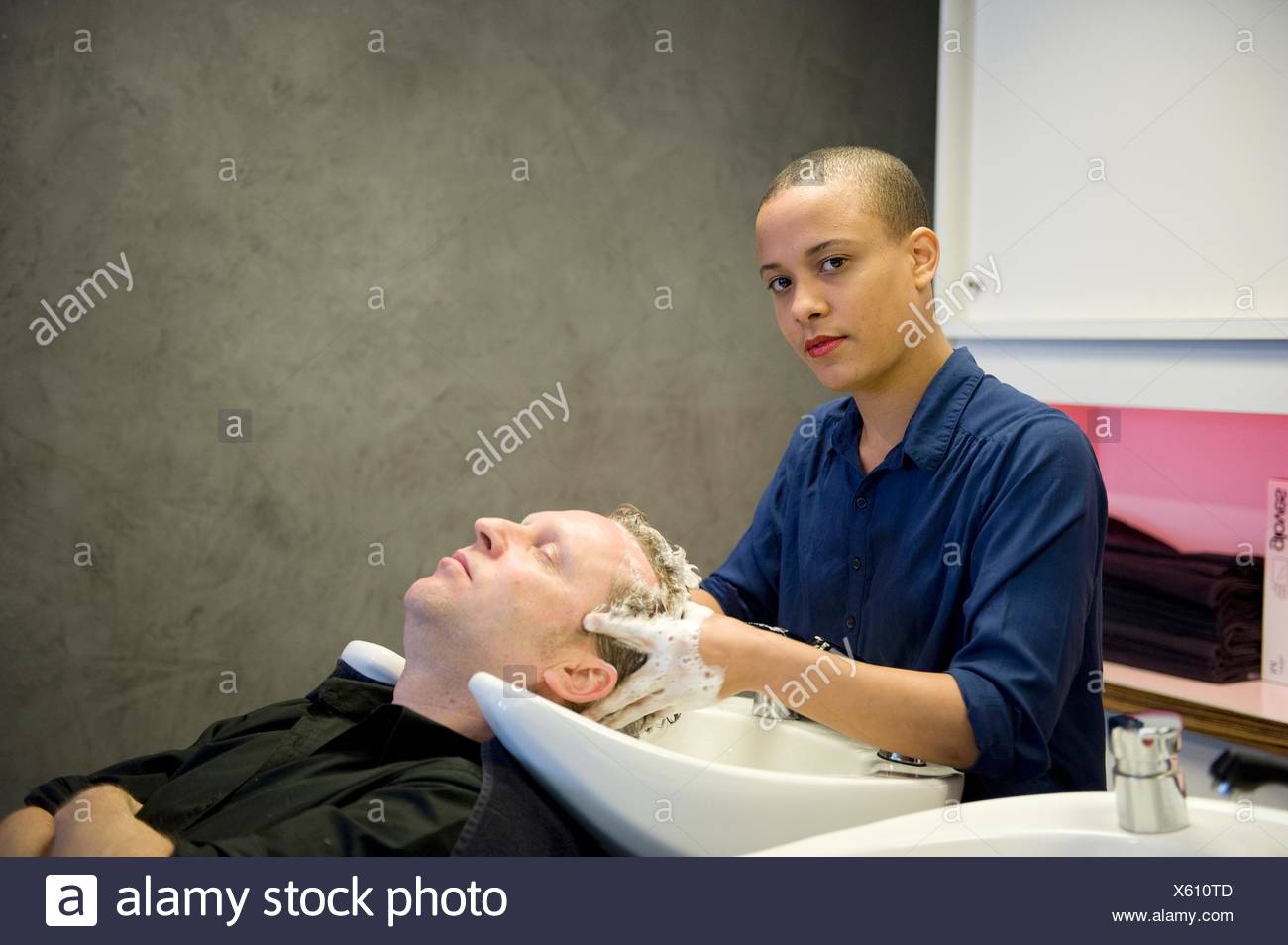 Young African Woman An Apprentice Hair Stylist Washing The Hair