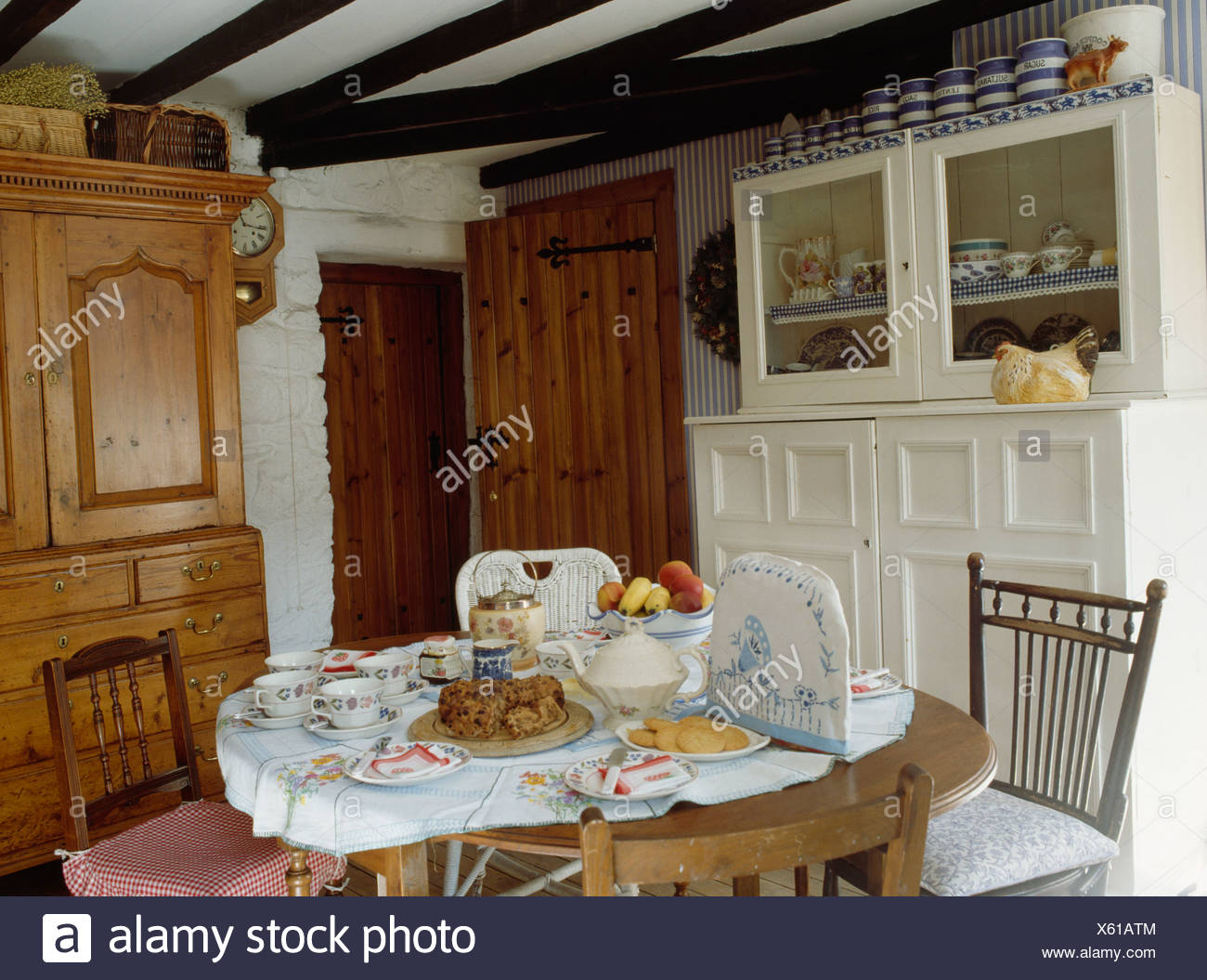 Table Set For Tea In Cottage Dining Room With White Cupboard