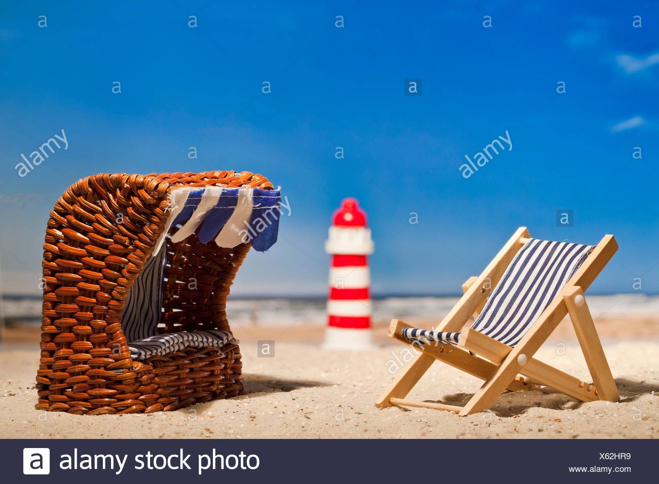 Still Life Of A Miniature Lighthouse Deck Chair And Roofed Wicker