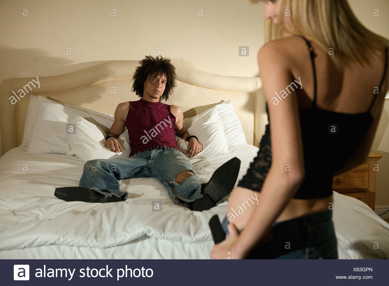 A Young Woman Stripping For A Young Man Stock Photo