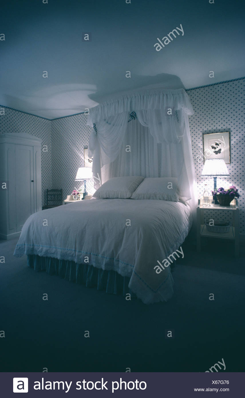 Traditional Bedroom With White Voile Bed Curtains And Light