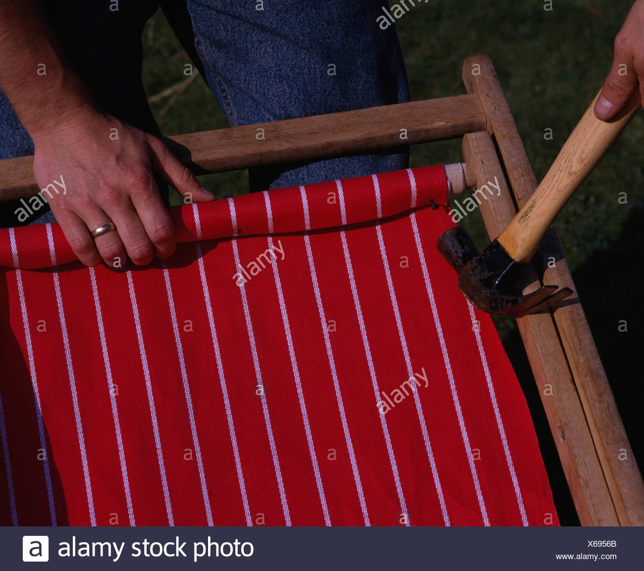 Close Up Of Hands Replacing Canvas On Deck Chair Stock Photo