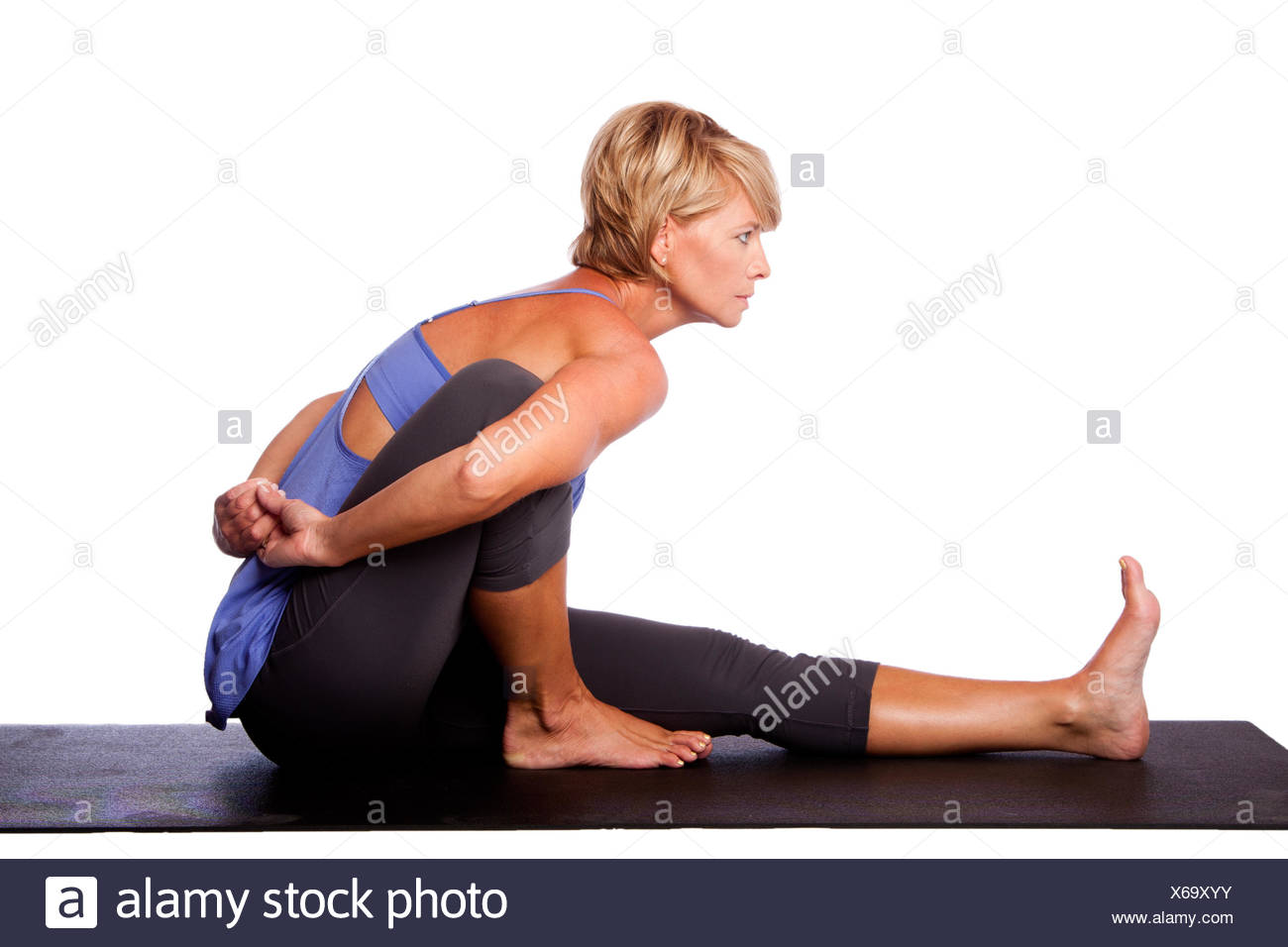 Beautiful woman in Seated Spinal Twist Marichyasana yoga pose Beautiful woman in Seated Spinal Twist Marichyasana yoga pose