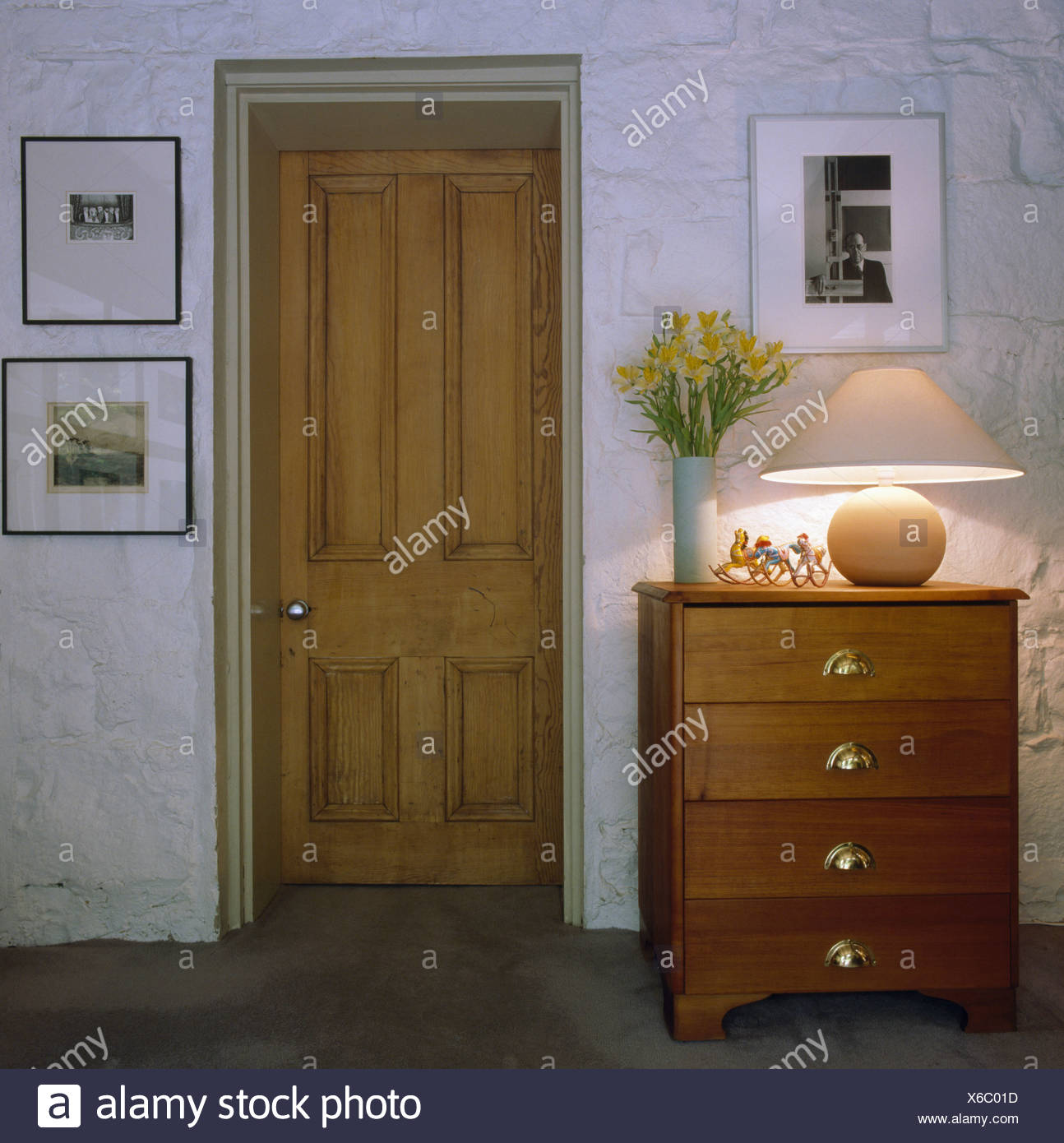 Lighted Lamp On Pine Chest Of Drawers Beside Wood Door In Small