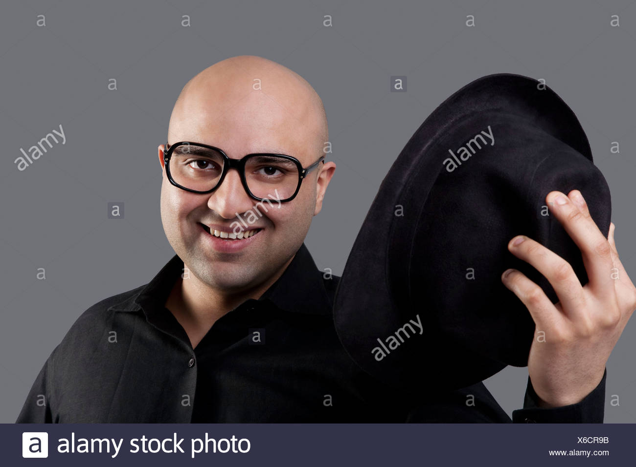 Bald man taking off his hat Stock Photo