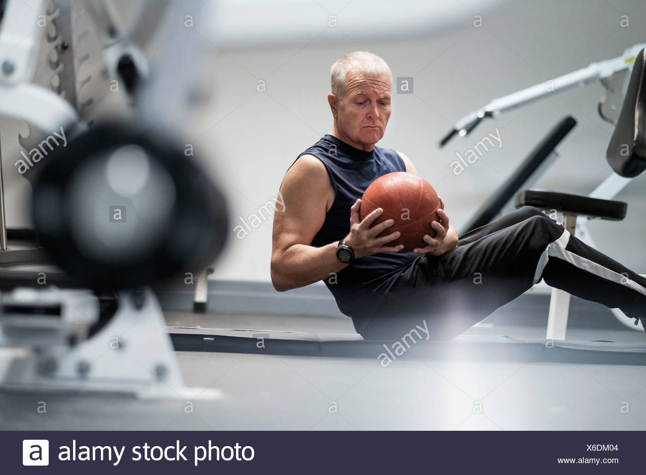 Man in health club exercising with ball Stock Photo
