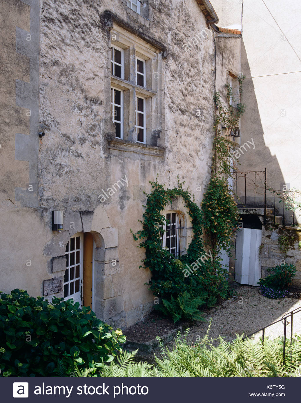 Exterior Of Stone French Country House With Climbing Plant On Wall