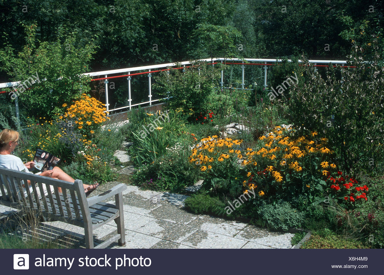 Roof Garden With Woman Sitting On Garden Bench Stock Photo