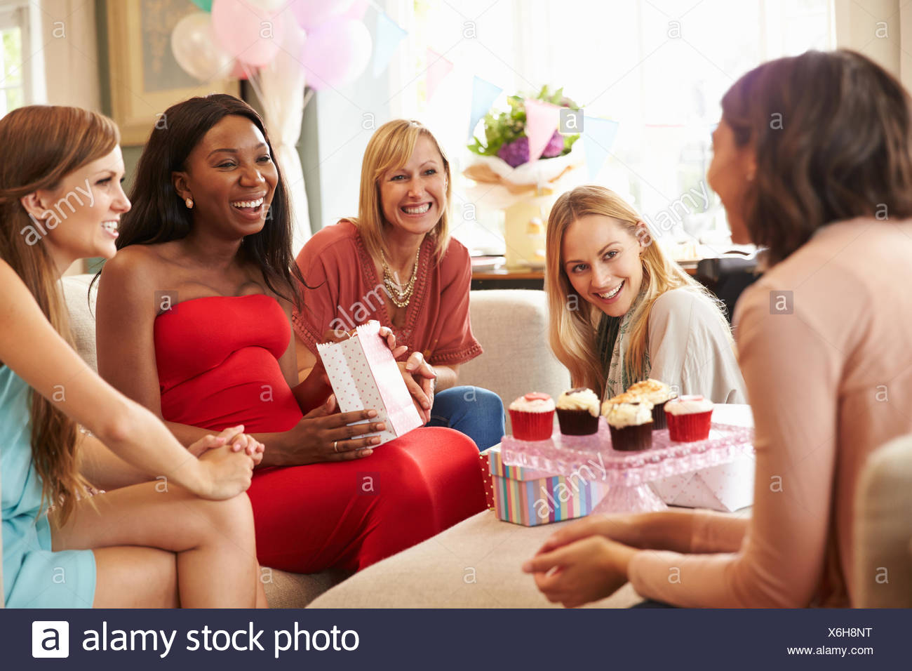 Group Of Female Friends Meeting For Baby Shower At Home Stock Photo