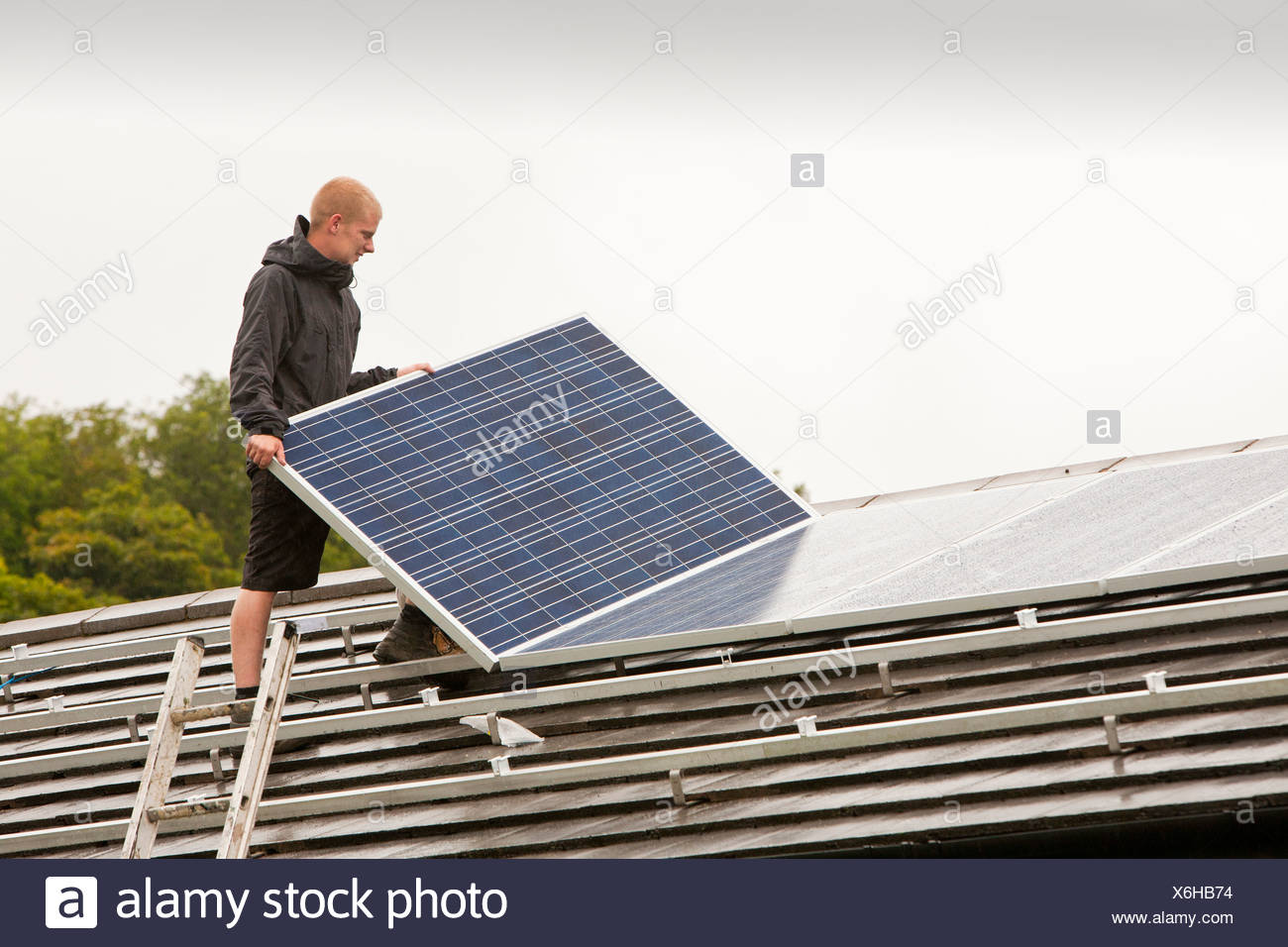 Workers Fitting A 4 Kw System Of Solar Panels To A House