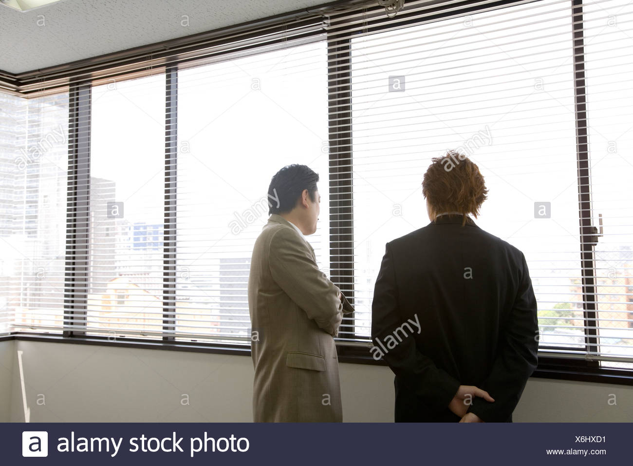 Two People Looking Through Blinds Stock Photo Alamy