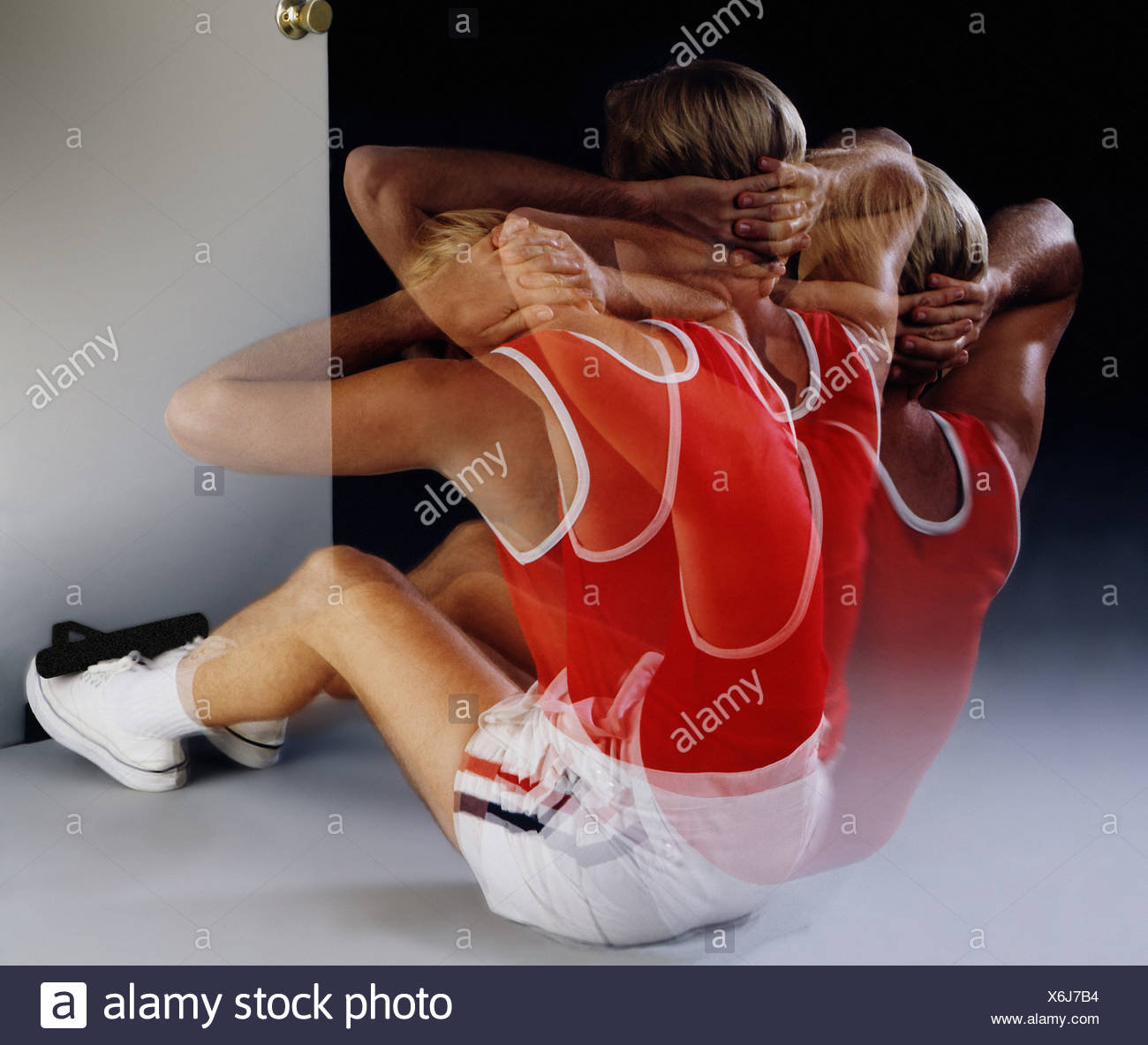 Man In Athletic Attire Doing Sit Ups On Ground Feet Held By Door