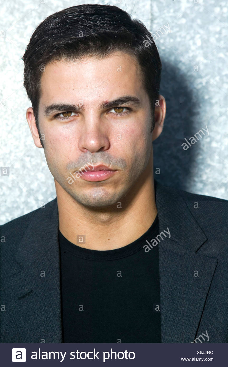 Male With Short Black Hair Wearing A Black T Shirt And A