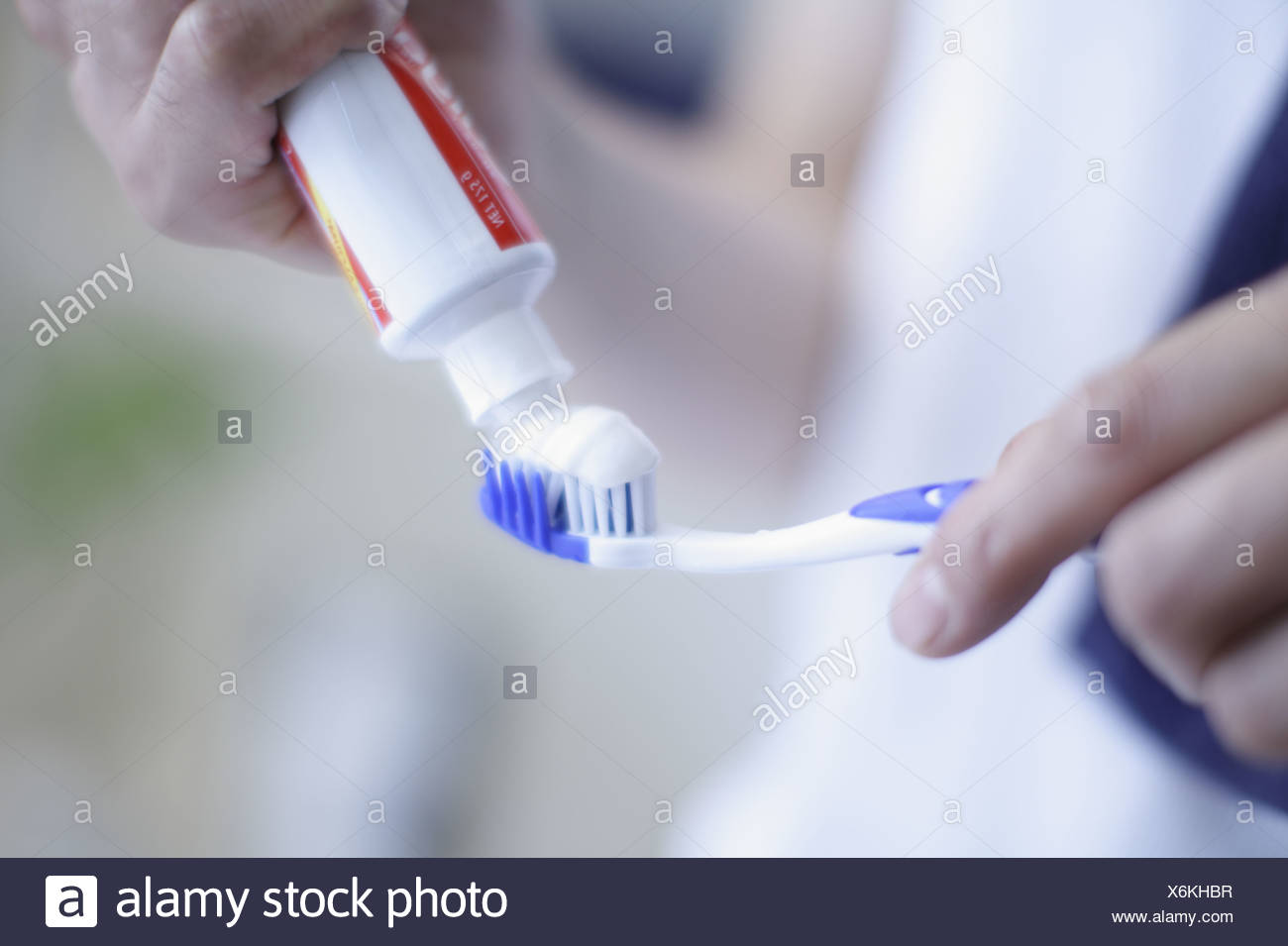 putting toothpaste on toothbrush