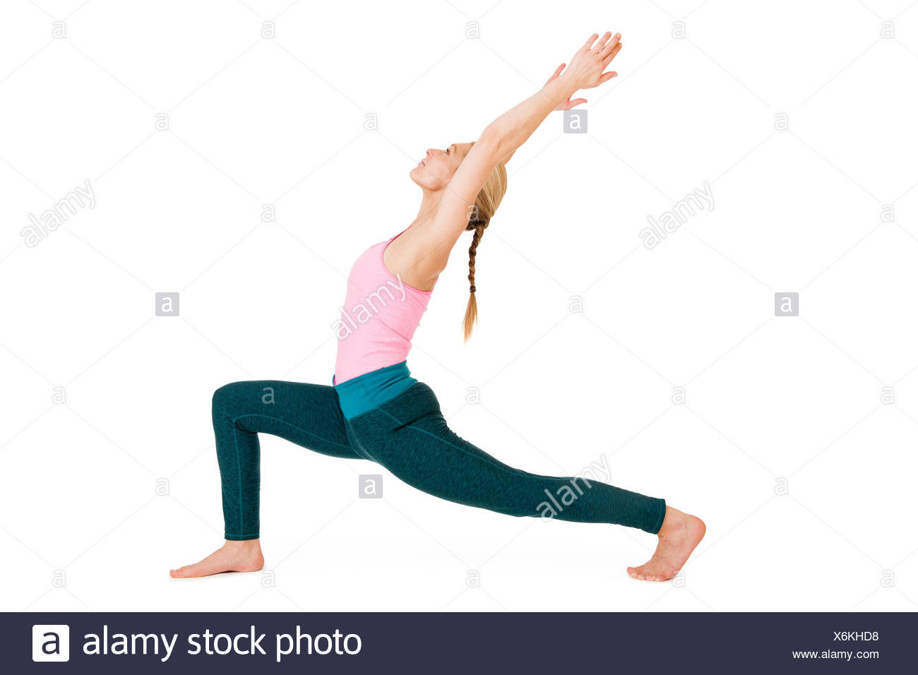 Seitliche Ganzkörper-Ansicht einer jungen Frau bei Yoga-Übung "der Krieger 1" (Virabhadrasana 1) vor weißen Hintergrund mit leichtem Schatten Stock Photo