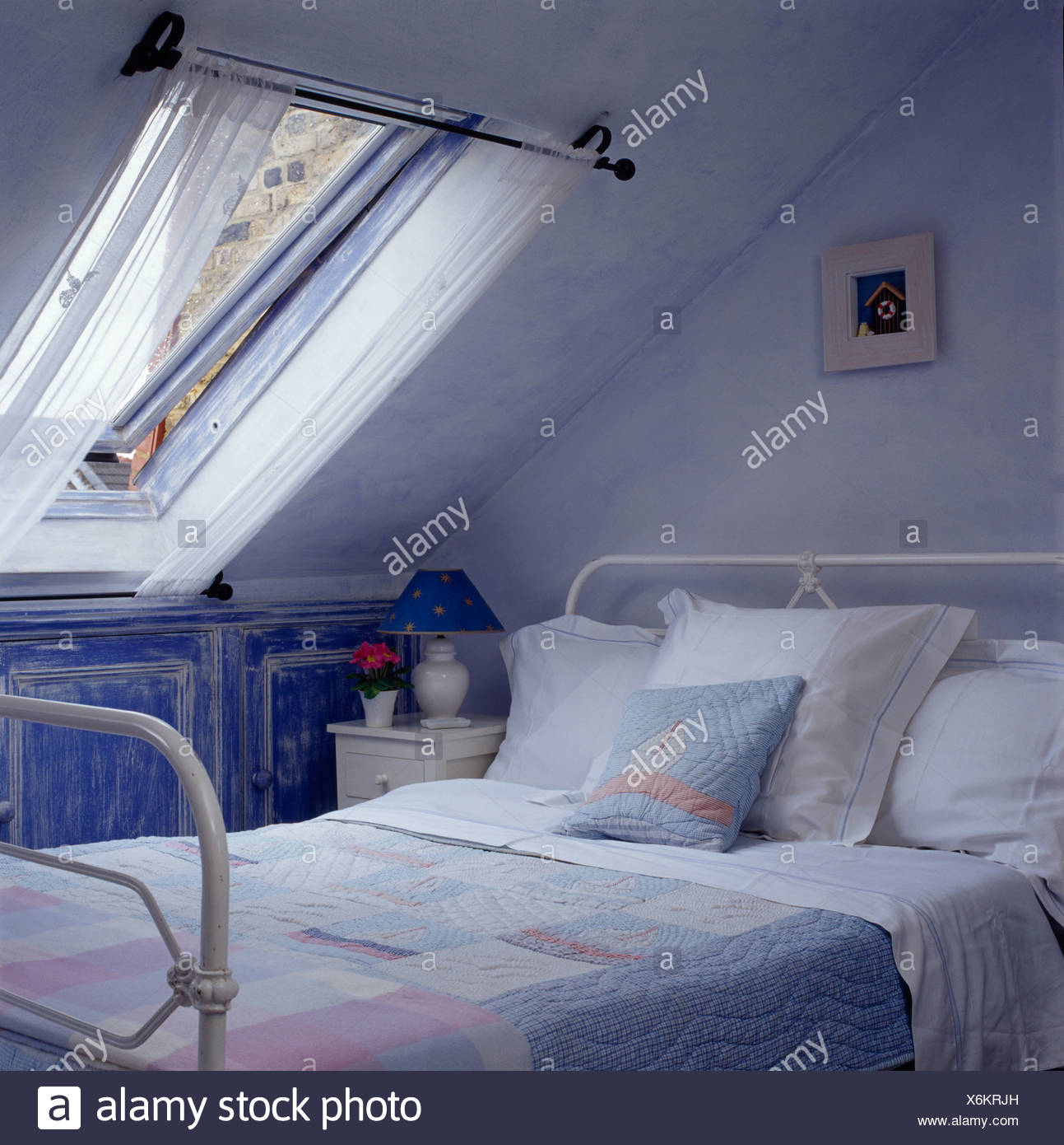 Pale Blue And White Pillows With Patchwork Quilt On Bed Below