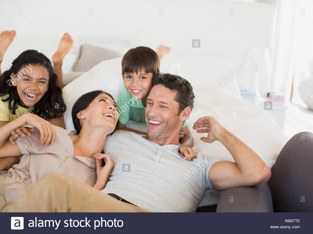Family Laughing And Relaxing On Sofa Stock Photo Alamy