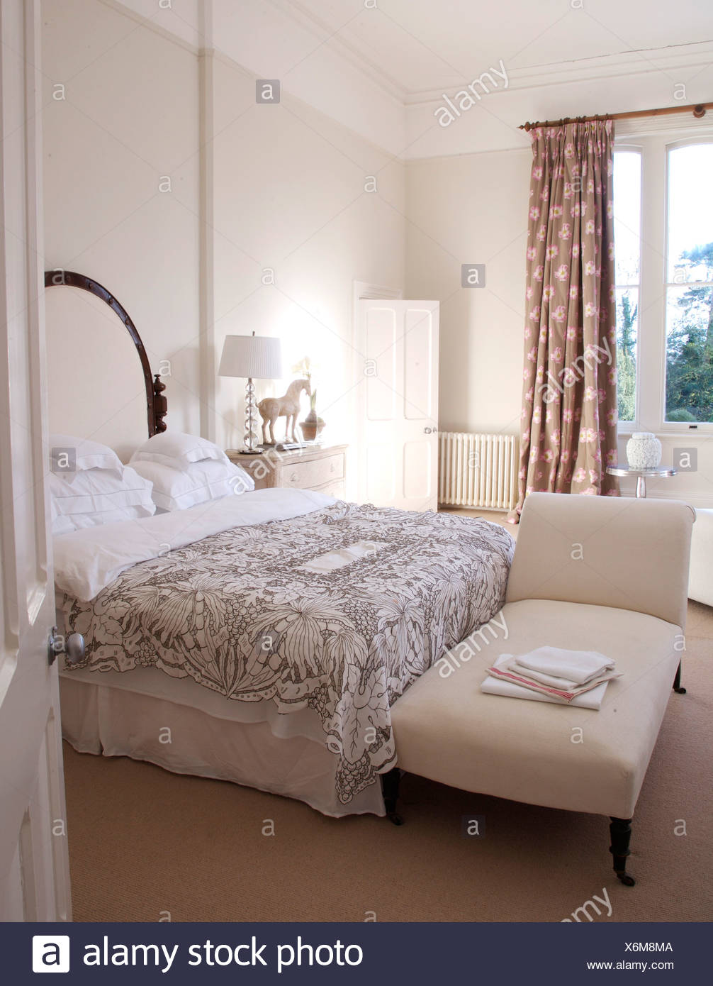 White Upholstered Chaise Longue At Foot Of Double Bed With White Pillows And Gray Patterned Bed Cover In White Bedroom Stock Photo Alamy