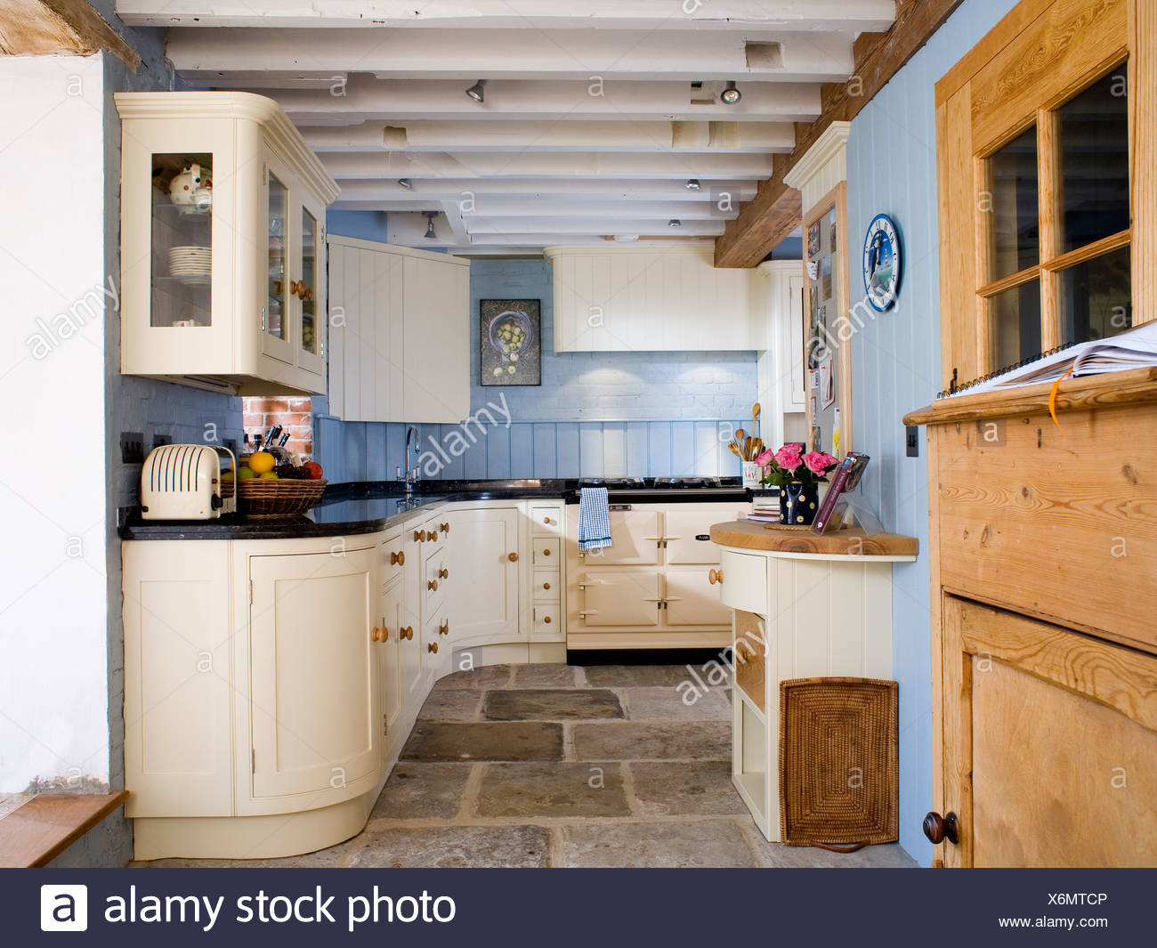 Fitted Cream Units And Flagstone Floor In Pastel Blue