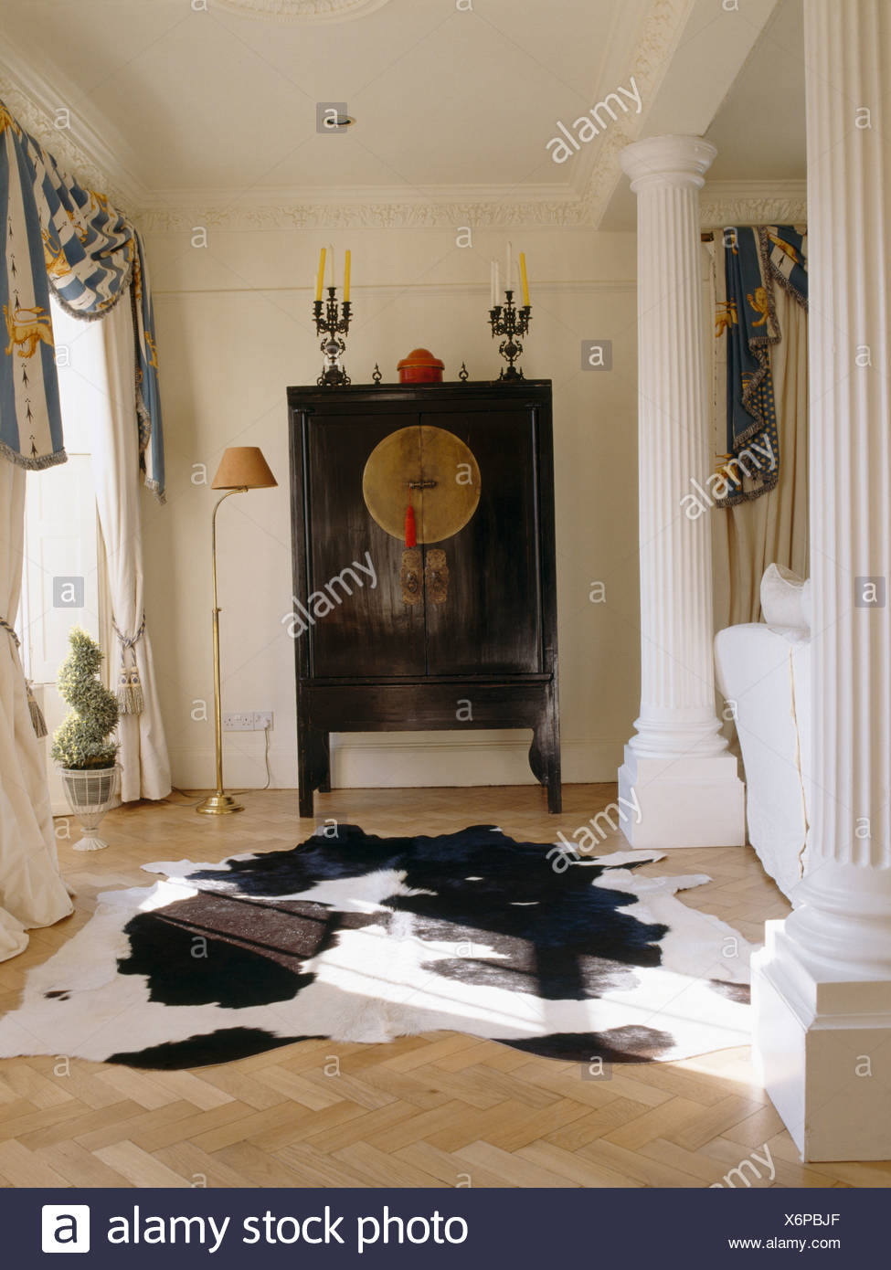 Cow Hide Rug On Parquet Floor In Country Living Room With Oriental