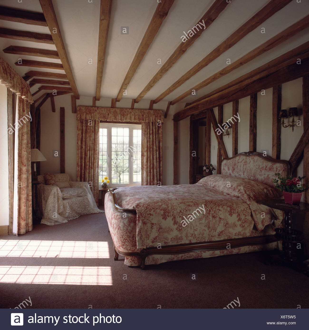 Country Bedroom With Beamed Walls And Bed With Upholstered