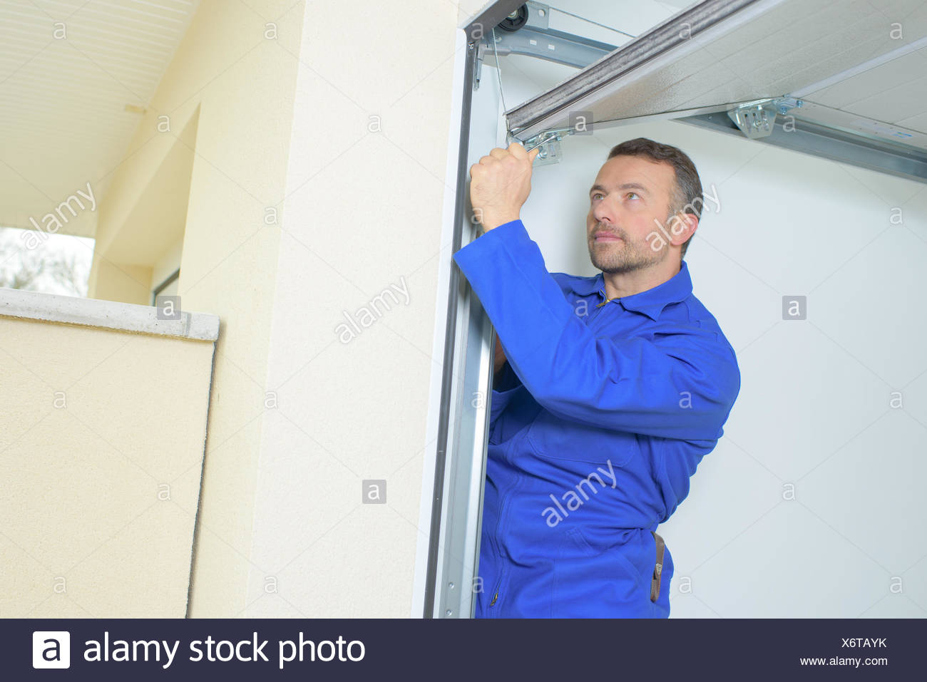 Man Fixing A Garage Door Stock Photo 279589287 Alamy