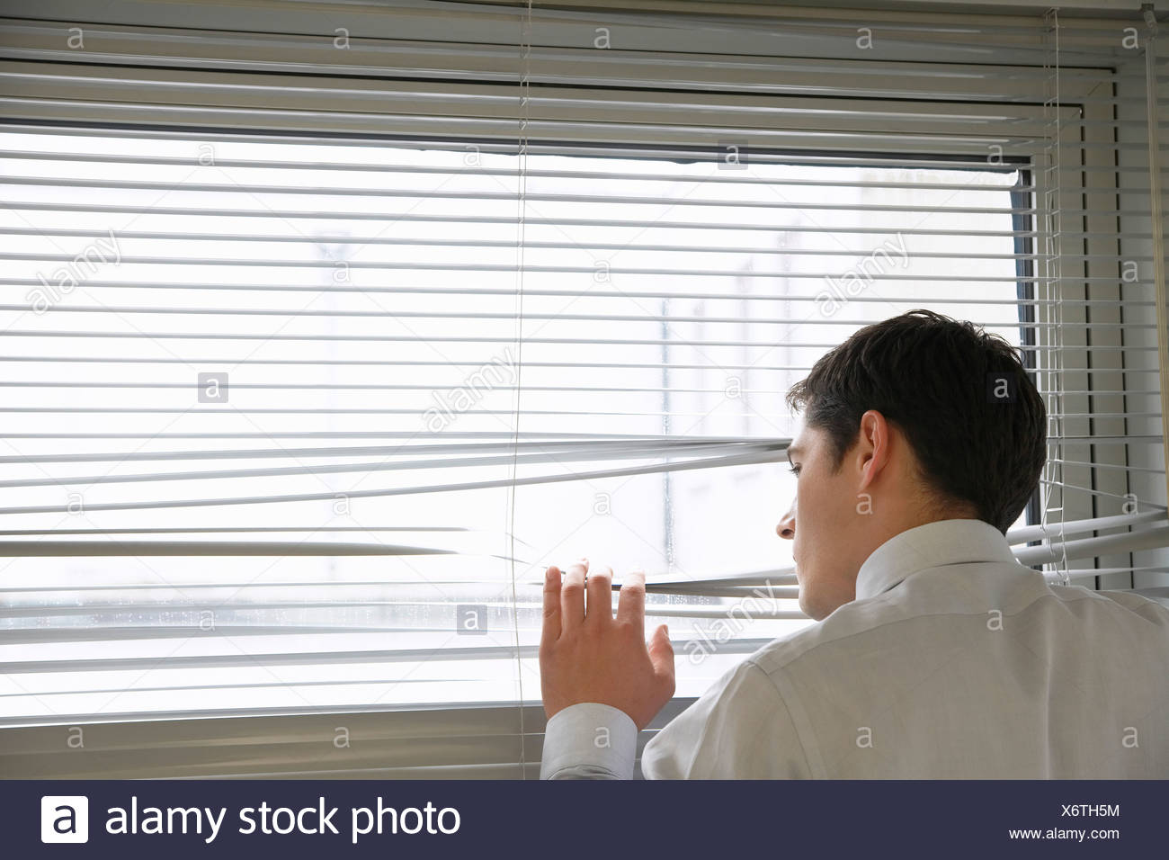 Businessman Looking Out Office Window Through Venetian Blinds Close Up View From Behind Stock Photo Alamy