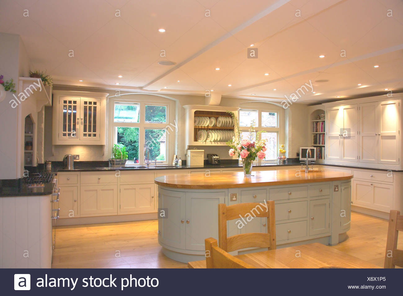 Wooden table and chairs in modern white kitchen with oval 